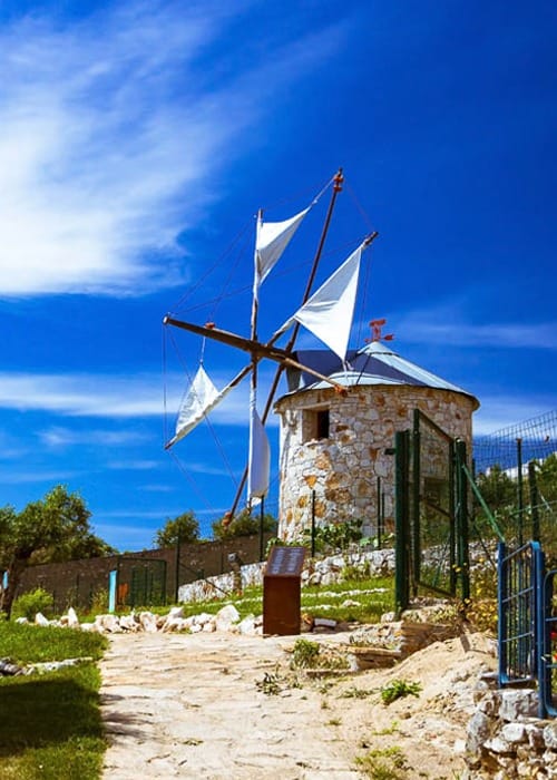 7. (2) a windmill with a white sails on top in Portugal