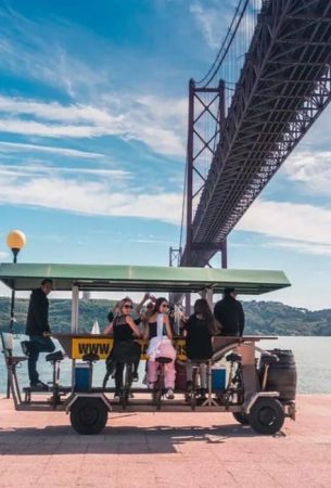 a group of people on a cart by a bridge in Portugal