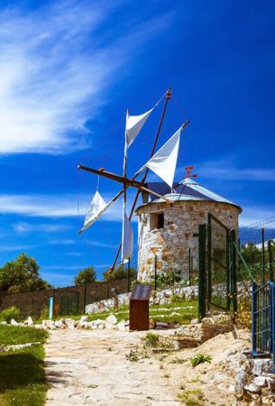 a windmill with a white sails on top in Portugal